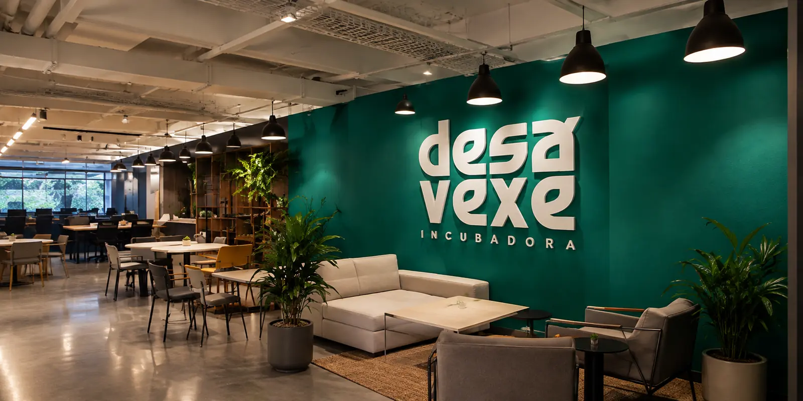 Espaço da DESAVEXE Incubadora, com o nome da marca na parede verde, sofá e poltronas à frente e mesas de trabalho ao fundo