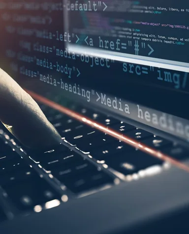 Mãos digitando num notebook, com marcação HTML projetada sobre a tela